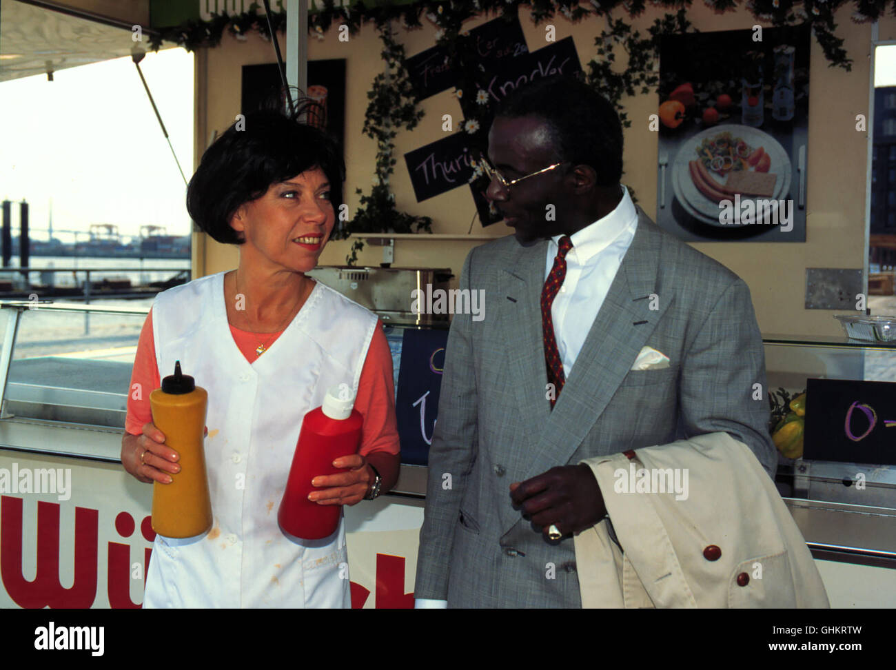 Als der Afrikanische Diplomat David (GILBERT ANDRE EHOULAN) von angpÜbelt Halbstarken wird die Imbißbudenbesitzerin propose, Kerstin (EVELYN HAMANN) meurent les bagarreurs beherzt dans die Flucht. aka. Le noir est beau Banque D'Images