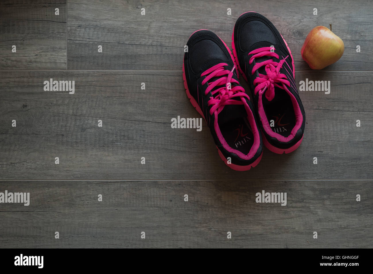 Chaussures de sport rose avec apple sur fond de bois Photo Stock - Alamy