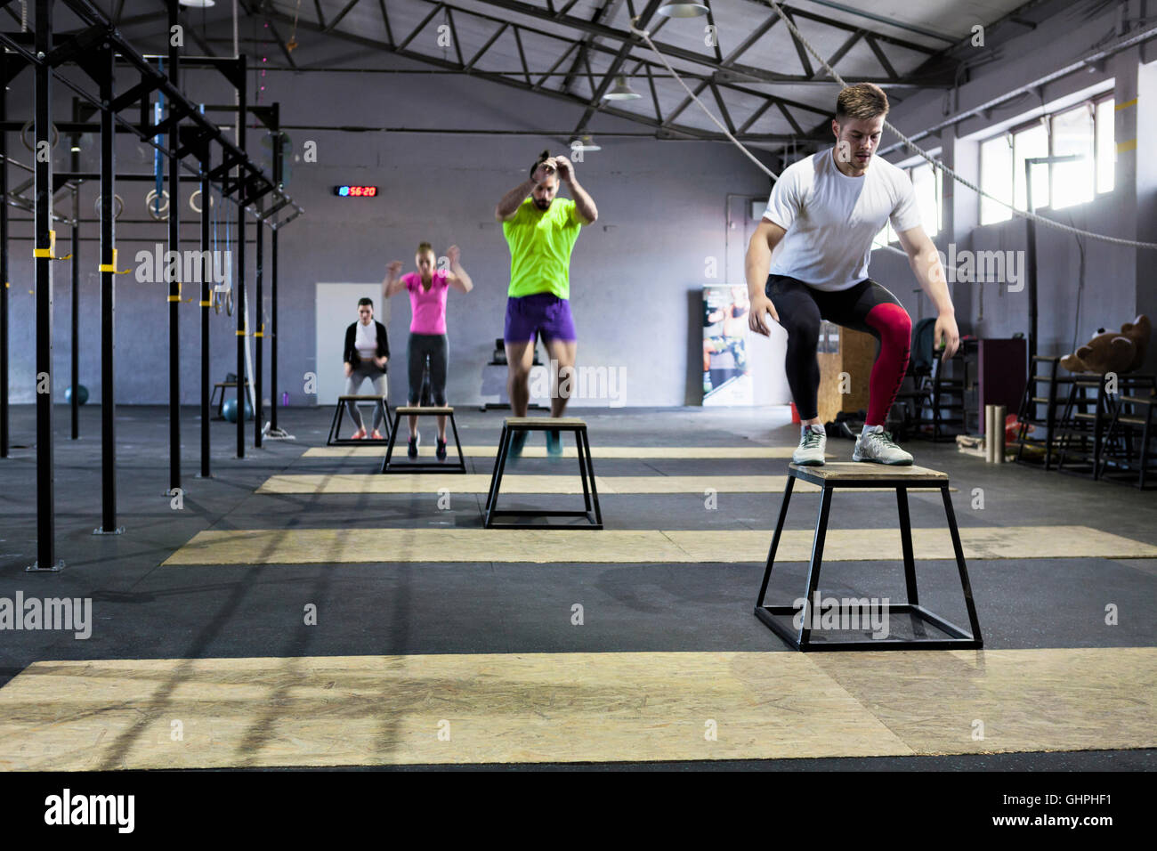 Les athlètes faisant fort sauts en salle de sport Banque D'Images