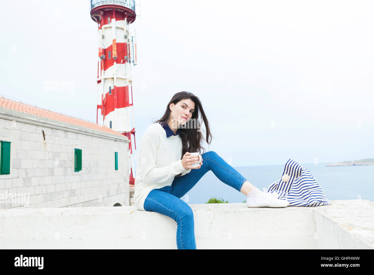 Jeune femme à boire le café au bord de la mer Banque D'Images