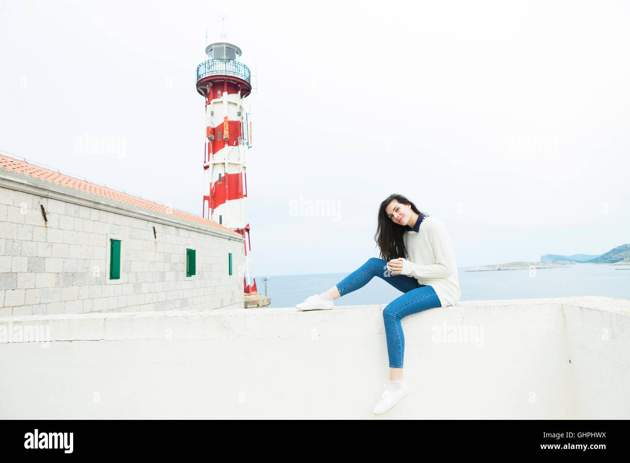 Jeune femme à boire le café au bord de la mer Banque D'Images