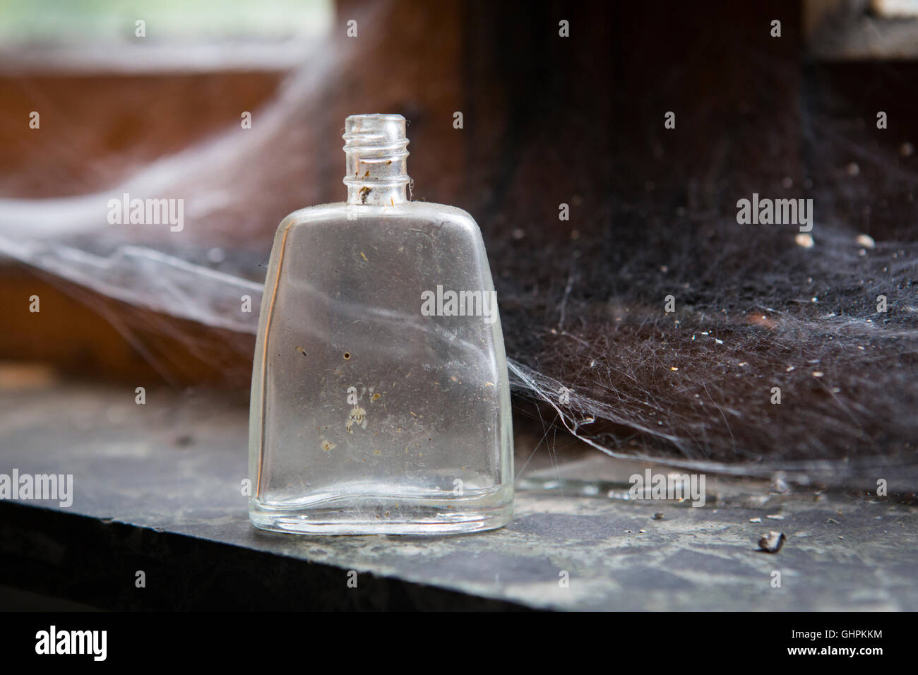 Petite bouteille vide pour les médicaments dans une fenêtre avec d'araignée Banque D'Images