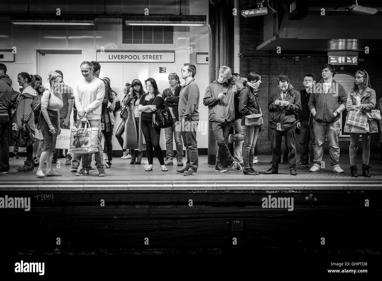 Passagers attendent sur la plate-forme d'un train sur le métro de Londres à Liverpool Street Banque D'Images