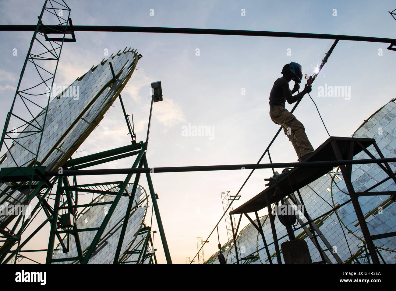 Le BURKINA FASO, Dano, transition énergétique, fondation Dreyer, moulin à riz avec four solaire, la vapeur est produite par miroir parabolique pour traiter le paddy, travailleur qualifié avec un chalumeau travaillant au système de tube d'eau Banque D'Images