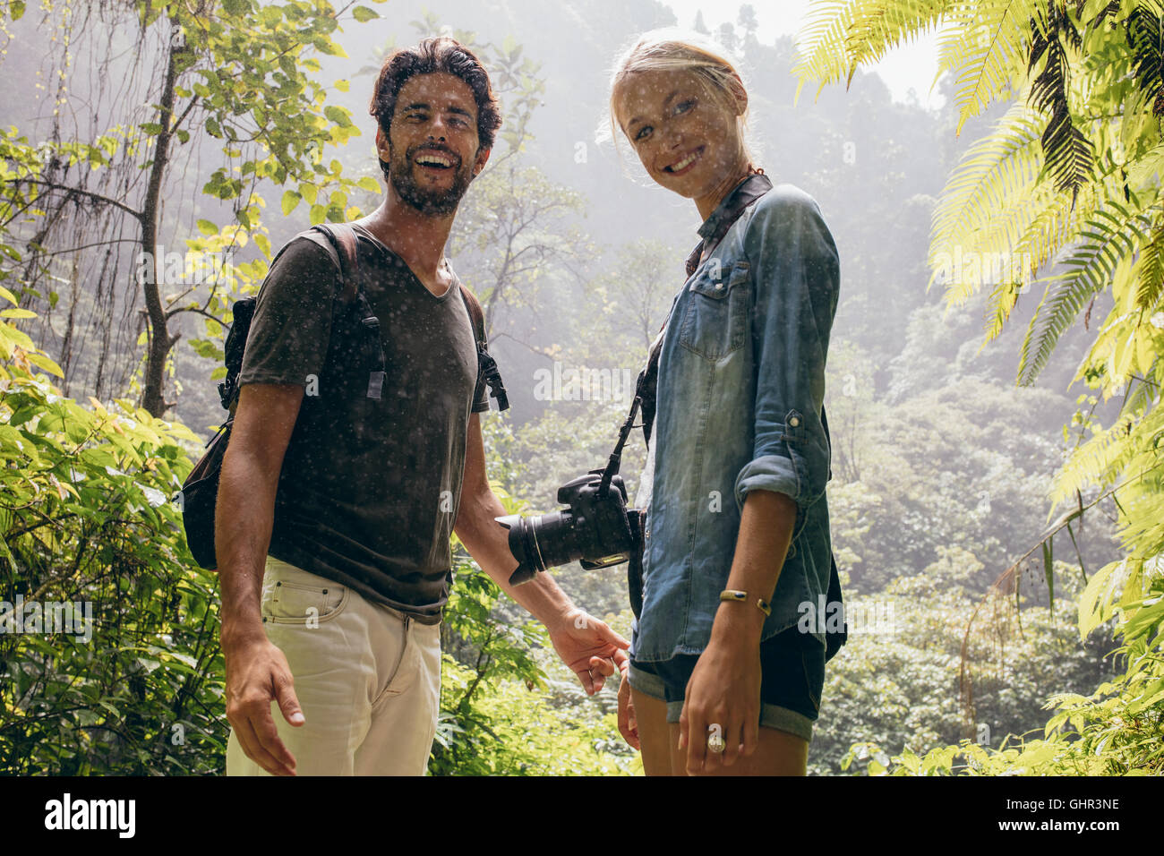 Portrait of happy young couple sous la pluie dans la forêt. Tourisme randonnée pédestre en forêt. Banque D'Images