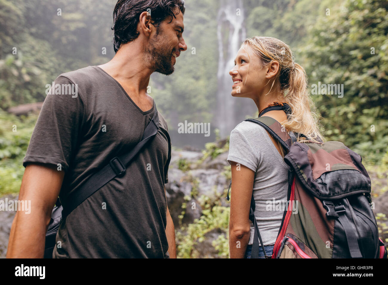 Coup de jeune couple romantique ensemble à la randonnée. Jeune homme et femme avec sac à dos en randonnée dans la nature à l'un l'autre et smi Banque D'Images