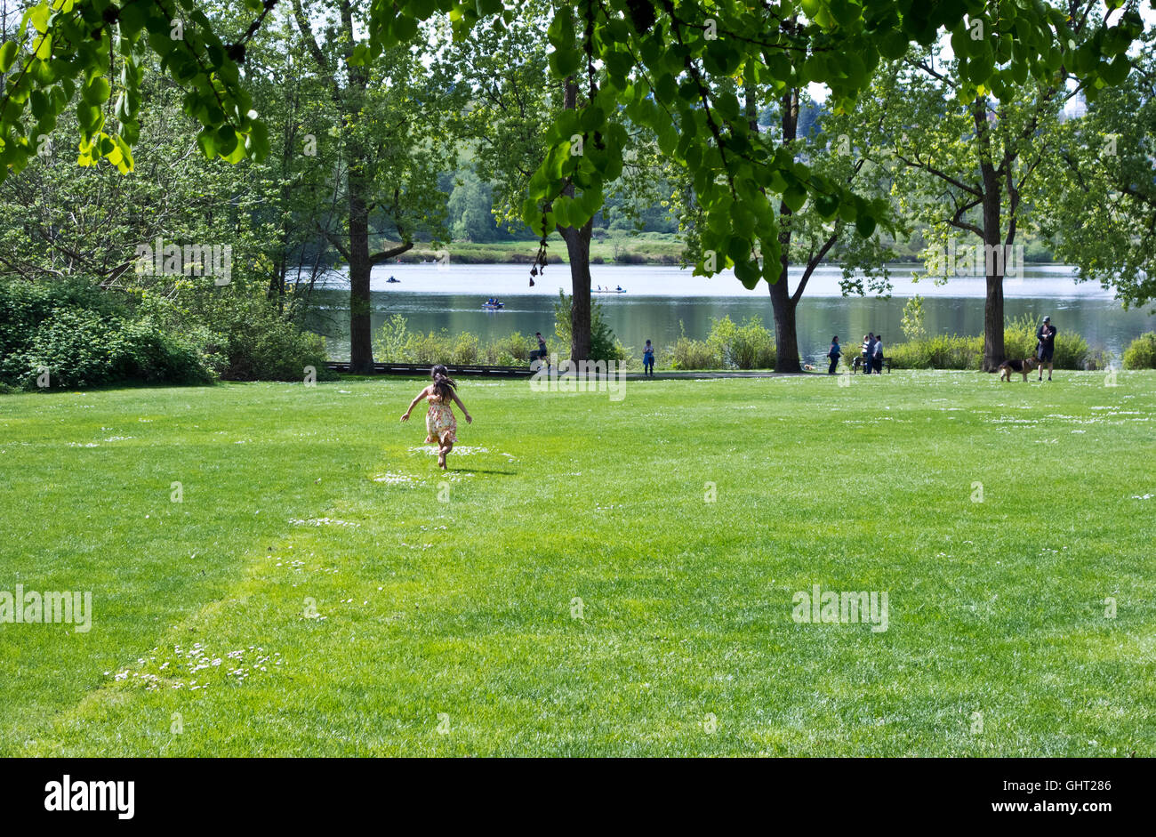 Fille courir sur l'herbe à Deer Lake Park, à Burnaby, en Colombie-Britannique, au printemps. Banque D'Images