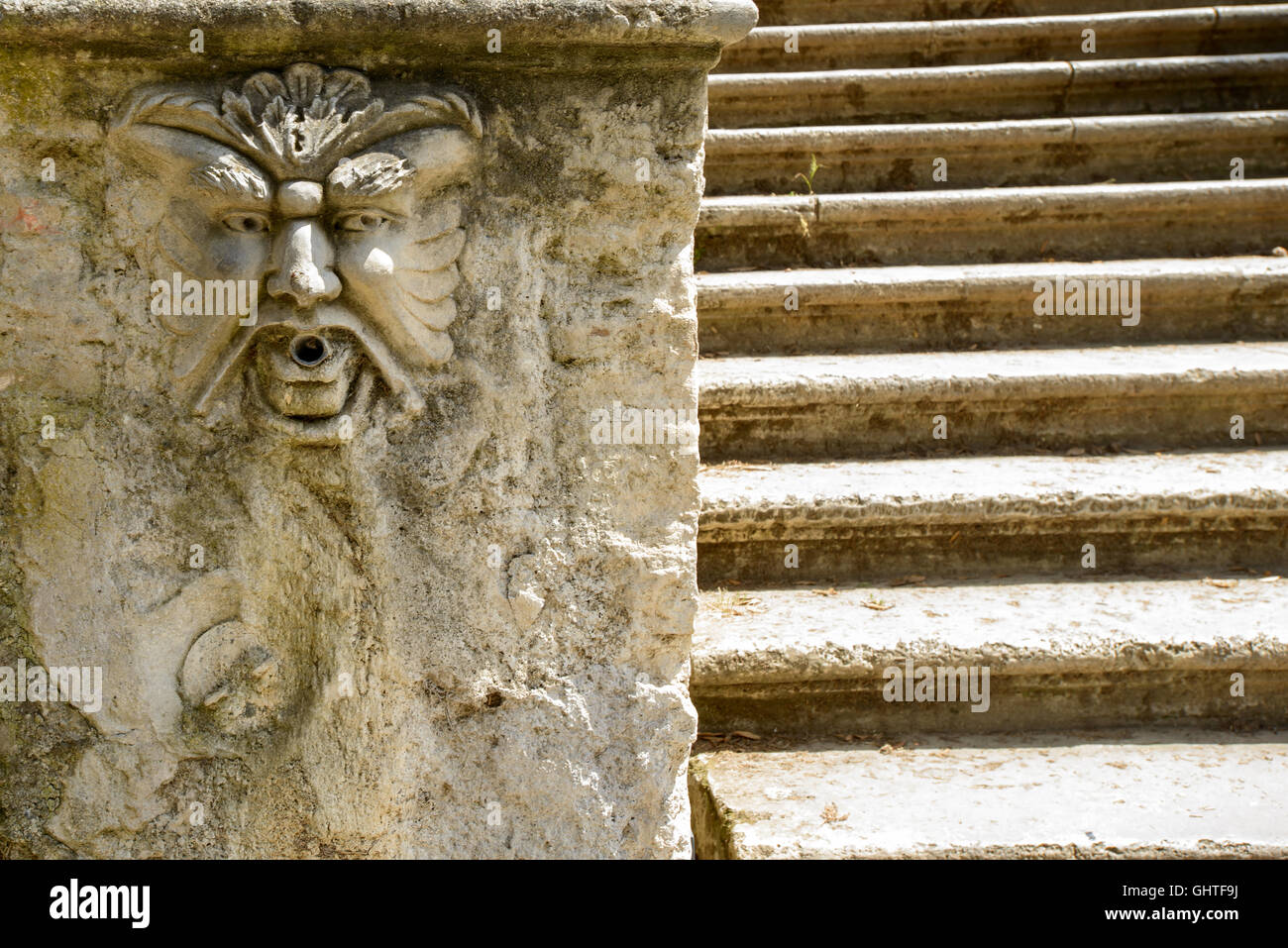 Un masque de marbre sur le côté d'un escalier Banque D'Images