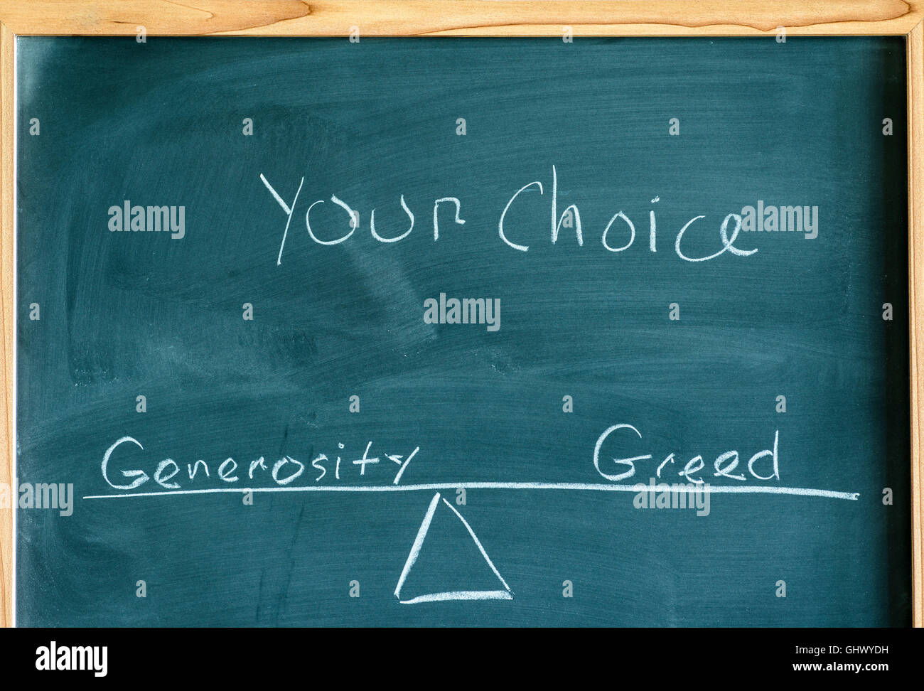 Les mots générosité et l'avidité sur une échelle en équilibre écrit sur un tableau. Banque D'Images