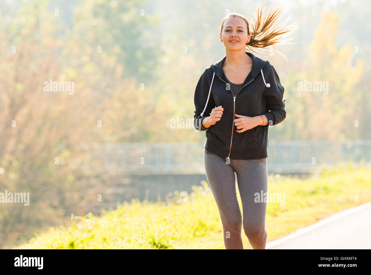 Jeune fille le jogging dans le parc Banque D'Images