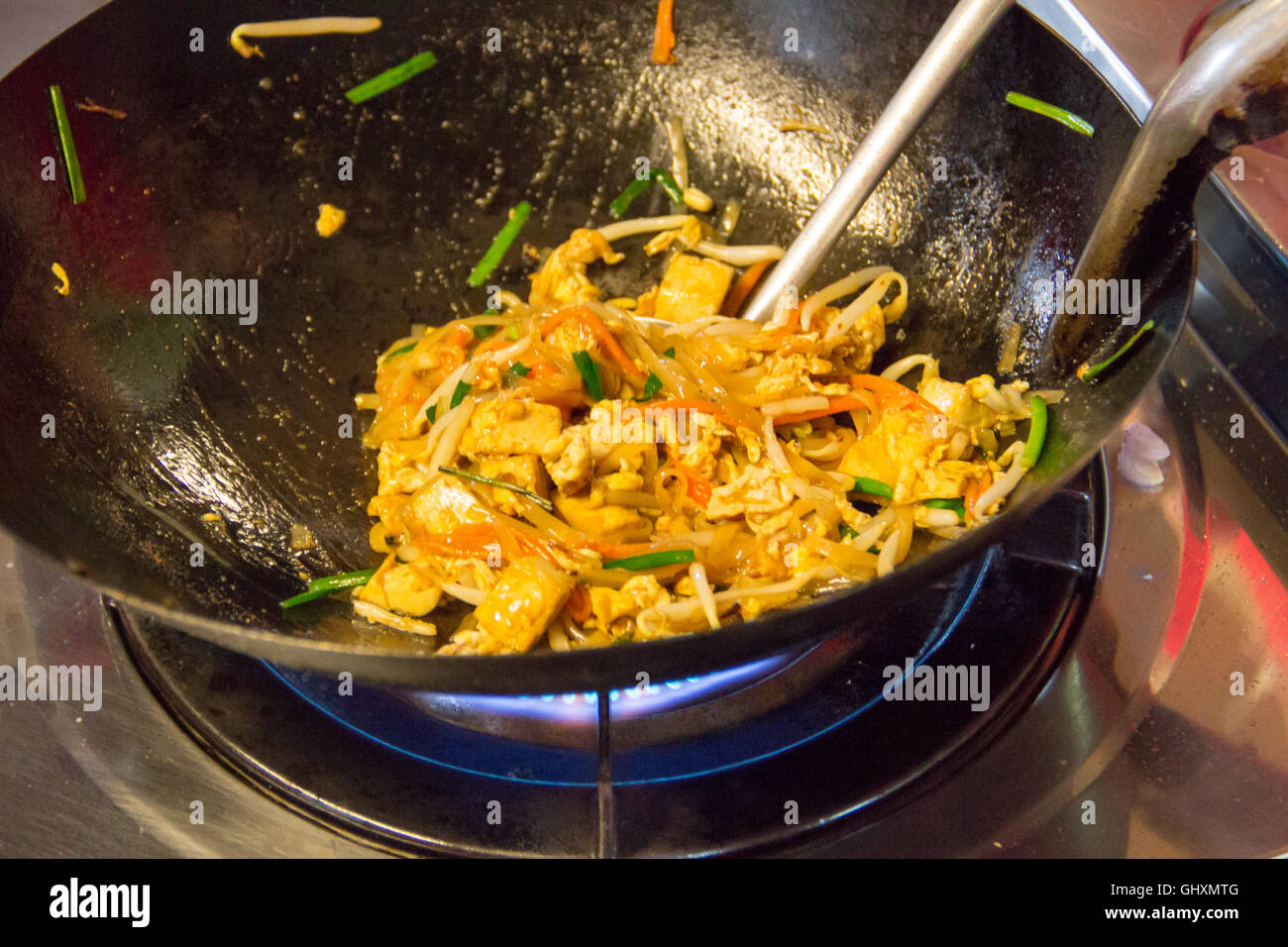 Remuer la friture Pad Thaï ingrédients dans un wok sur un poêle chaud Photo  Stock - Alamy