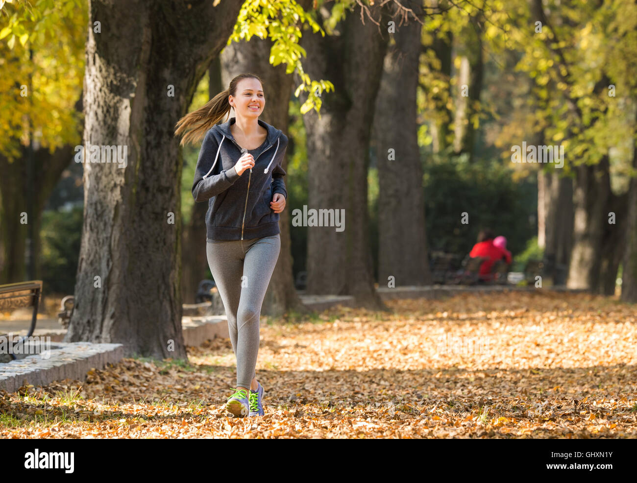 Jeune fille le jogging dans le parc Banque D'Images