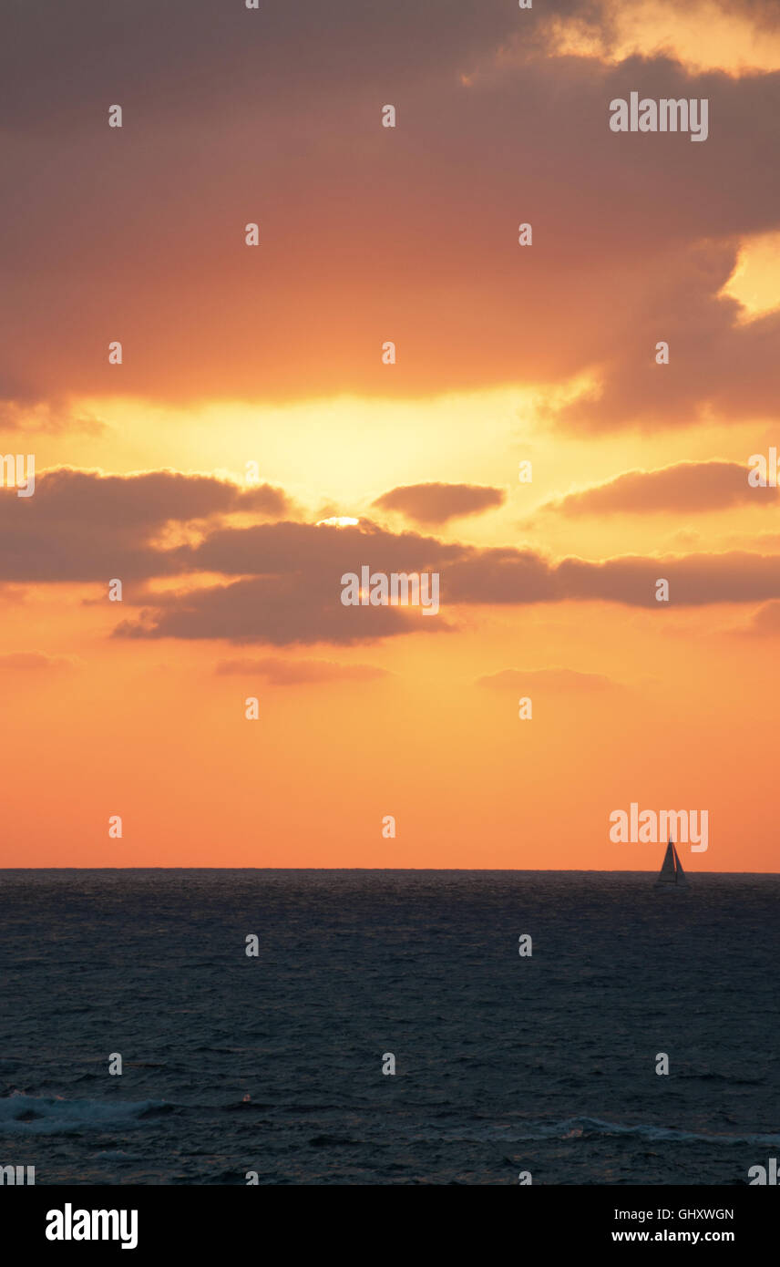 Tel Aviv, Israël, Moyen Orient : un splendide coucher de soleil sur la plage et d'un voilier naviguant sur la Mer Méditerranée Banque D'Images