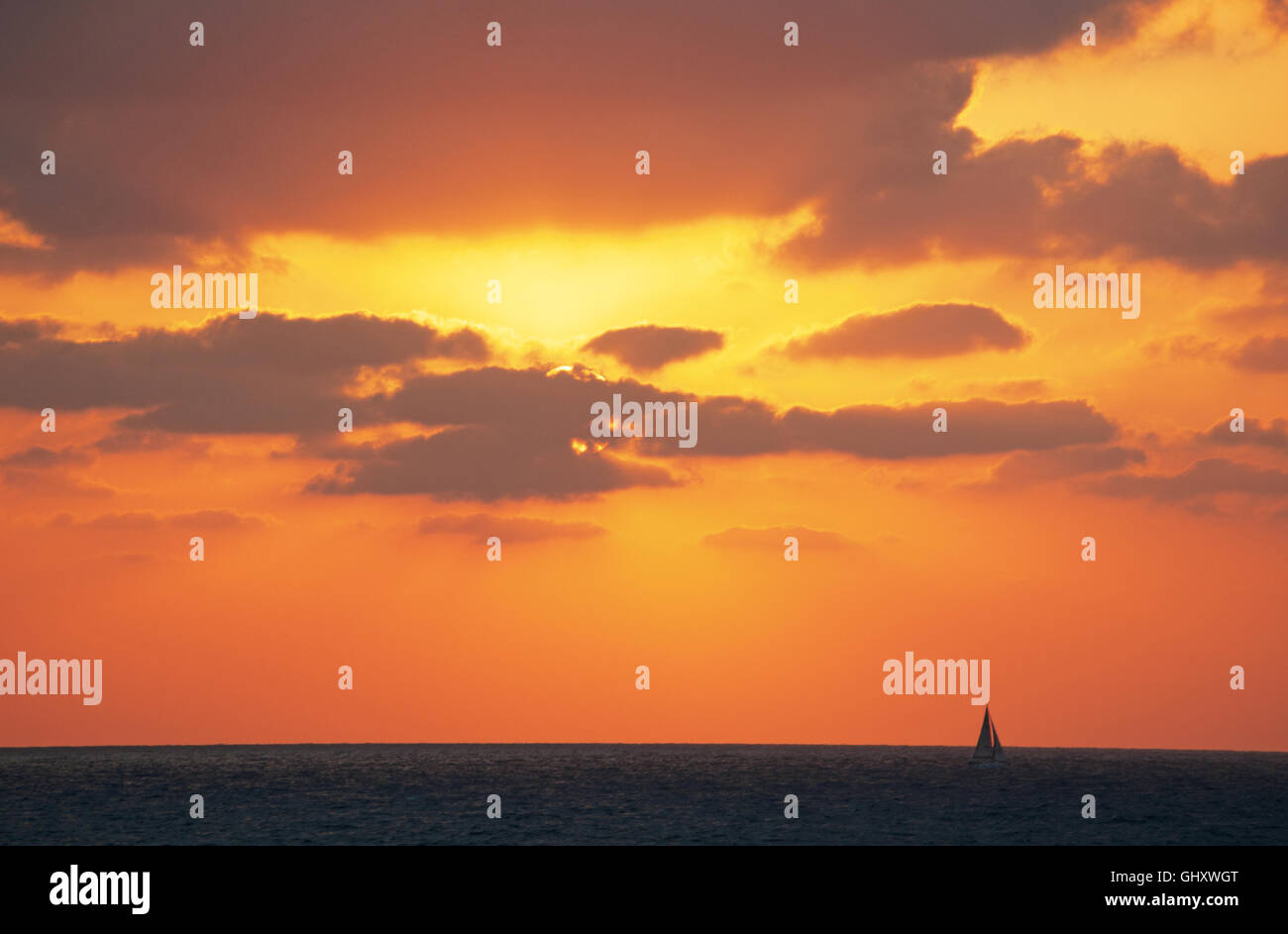 Tel Aviv, Israël, Moyen Orient : un splendide coucher de soleil sur la plage et d'un voilier naviguant sur la Mer Méditerranée Banque D'Images