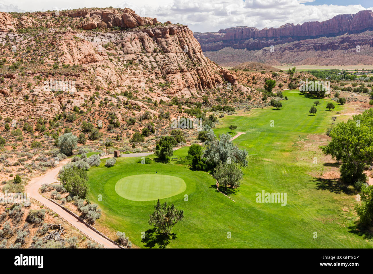 La 4e vert de la Moab golf niché dans une falaise de roche rouge dans Moab, Utah. Banque D'Images