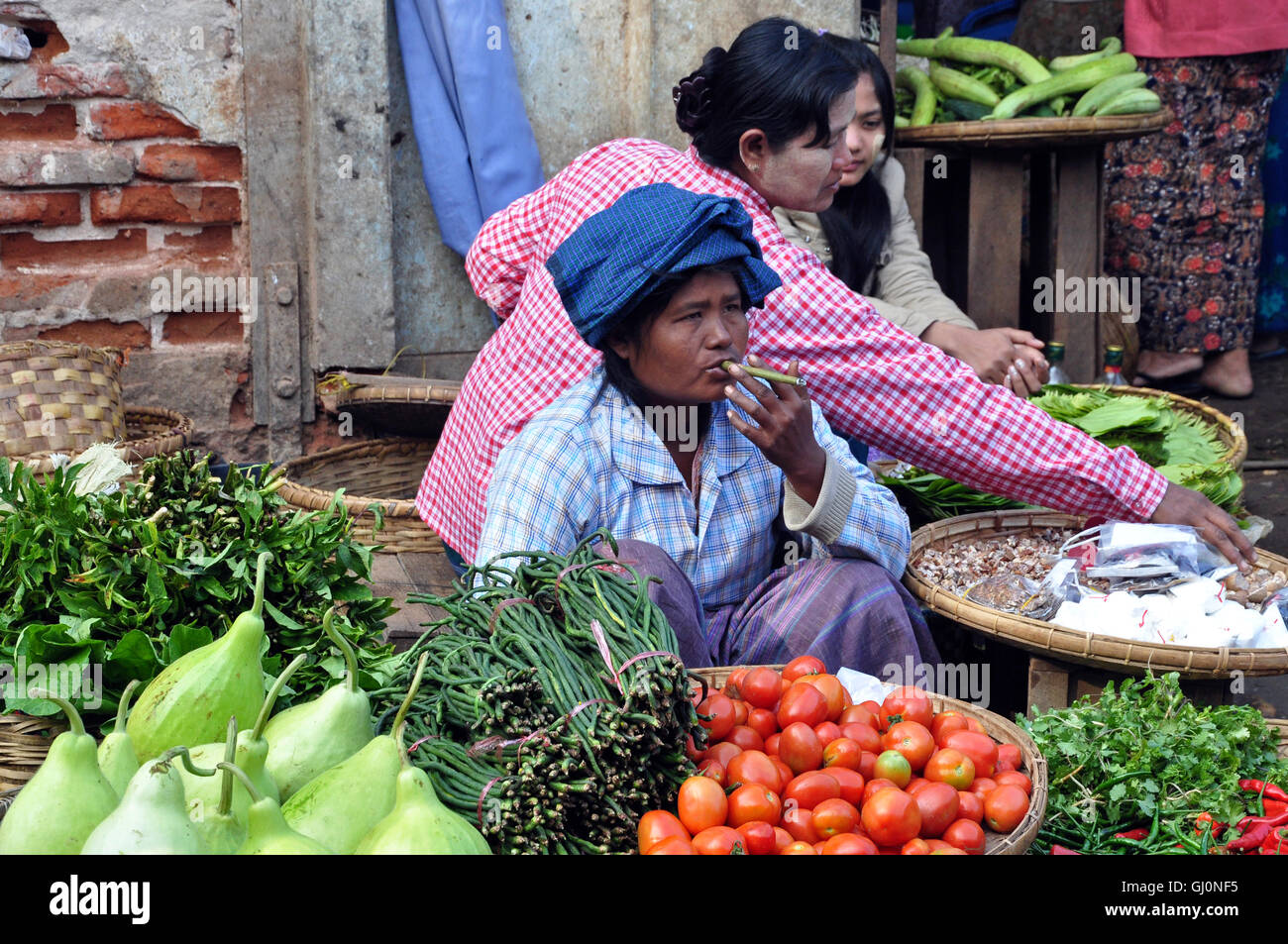 Dame fumeurs de cigare, Bagan, Myanmar les marchés de produits frais Banque D'Images