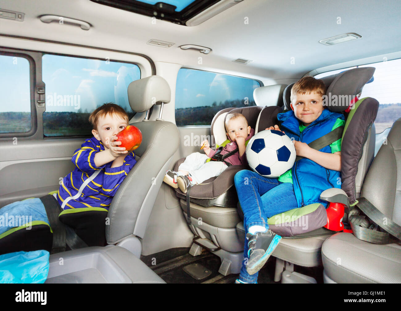 Cute little boys voyageant en voiture dans les sièges de sécurité Banque D'Images