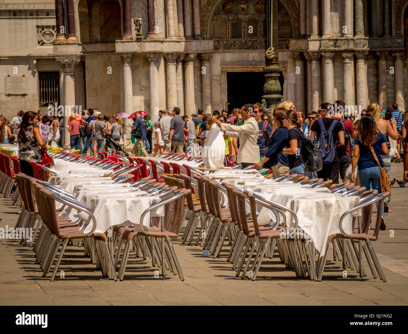 Café vide tables et chaises, ainsi que des foules de touristes de la Place Saint-Marc, Venise, Italie. Banque D'Images