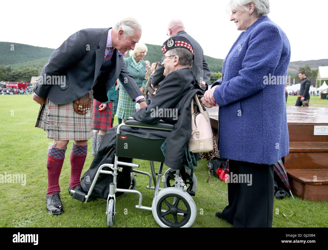 Le Prince de Galles, également connu sous le nom de duc de Rothesay, répond aux résidents locaux Ian Whyte, 70, un ancien sergent de l'Highlander Gordon et sa femme Alison qui sont toujours en train de se remettre des inondations dévastatrices de décembre 2015, au cours de la Highland Games à Monaltrie Park à Ballater, dans l'Aberdeenshire. Banque D'Images
