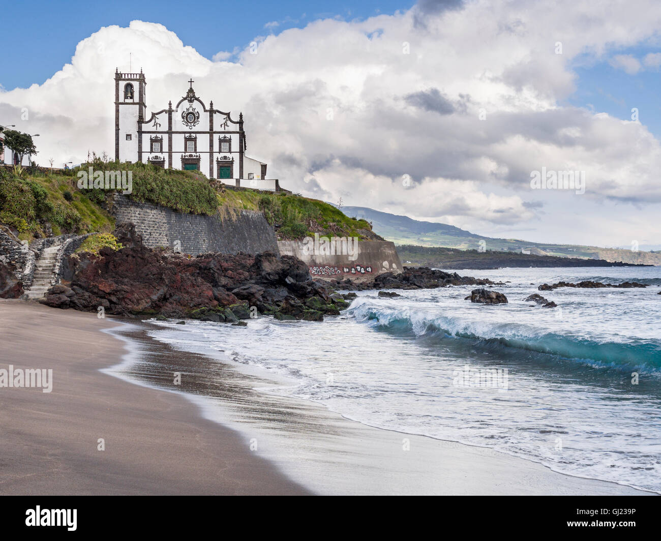 Plage de São Roque, vague et l'Église. Une vague de boucles la plage tranquille au-dessous de l'église São Roque, près de la capitale des. Banque D'Images