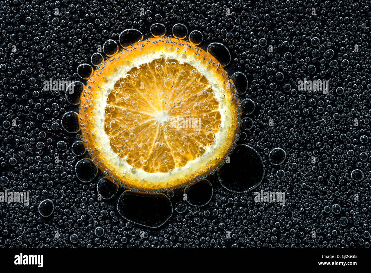 Tranche d'Orange dans de l'eau minérale, une série de photos. Close-up de l'eau gazéifiée sur fond noir Banque D'Images