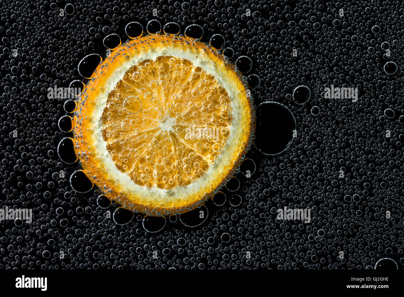 Tranche d'Orange dans de l'eau minérale, une série de photos. Close-up de l'eau gazéifiée sur fond noir Banque D'Images
