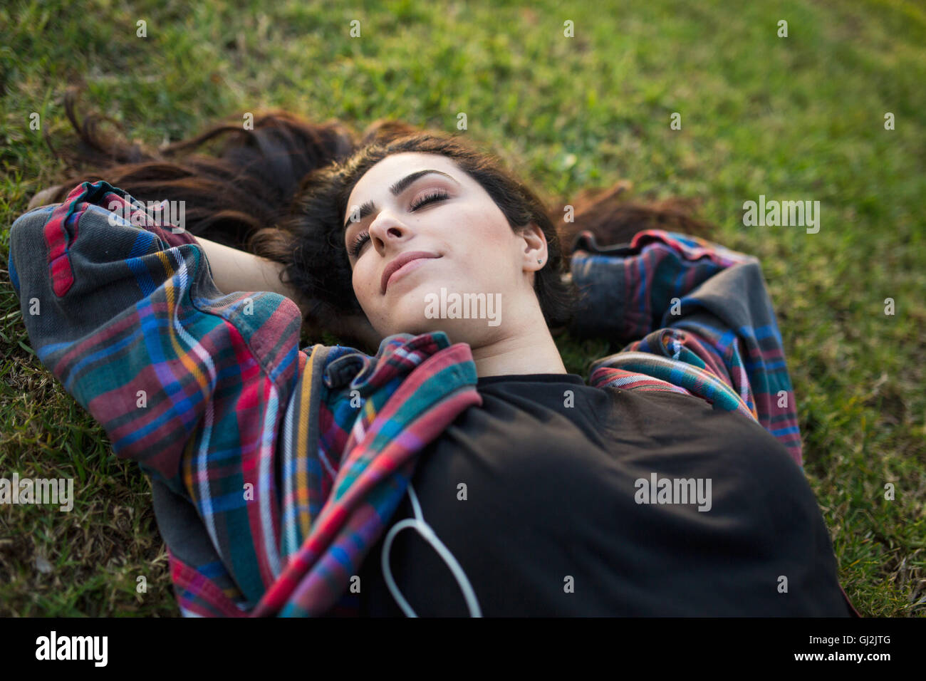 Jeune femme allongée sur l'herbe, les yeux fermés Banque D'Images