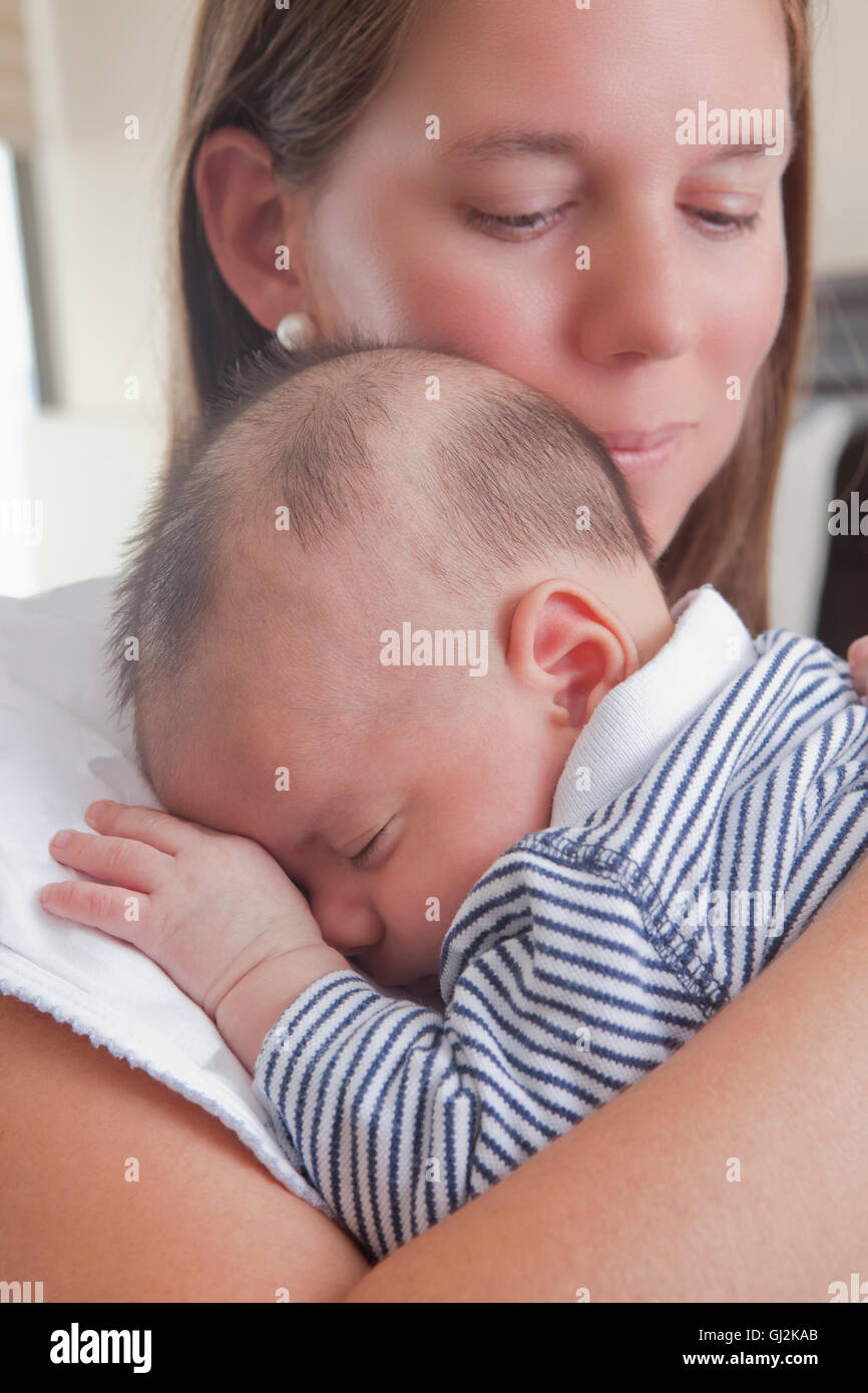 Mother holding sleeping baby boy Banque D'Images