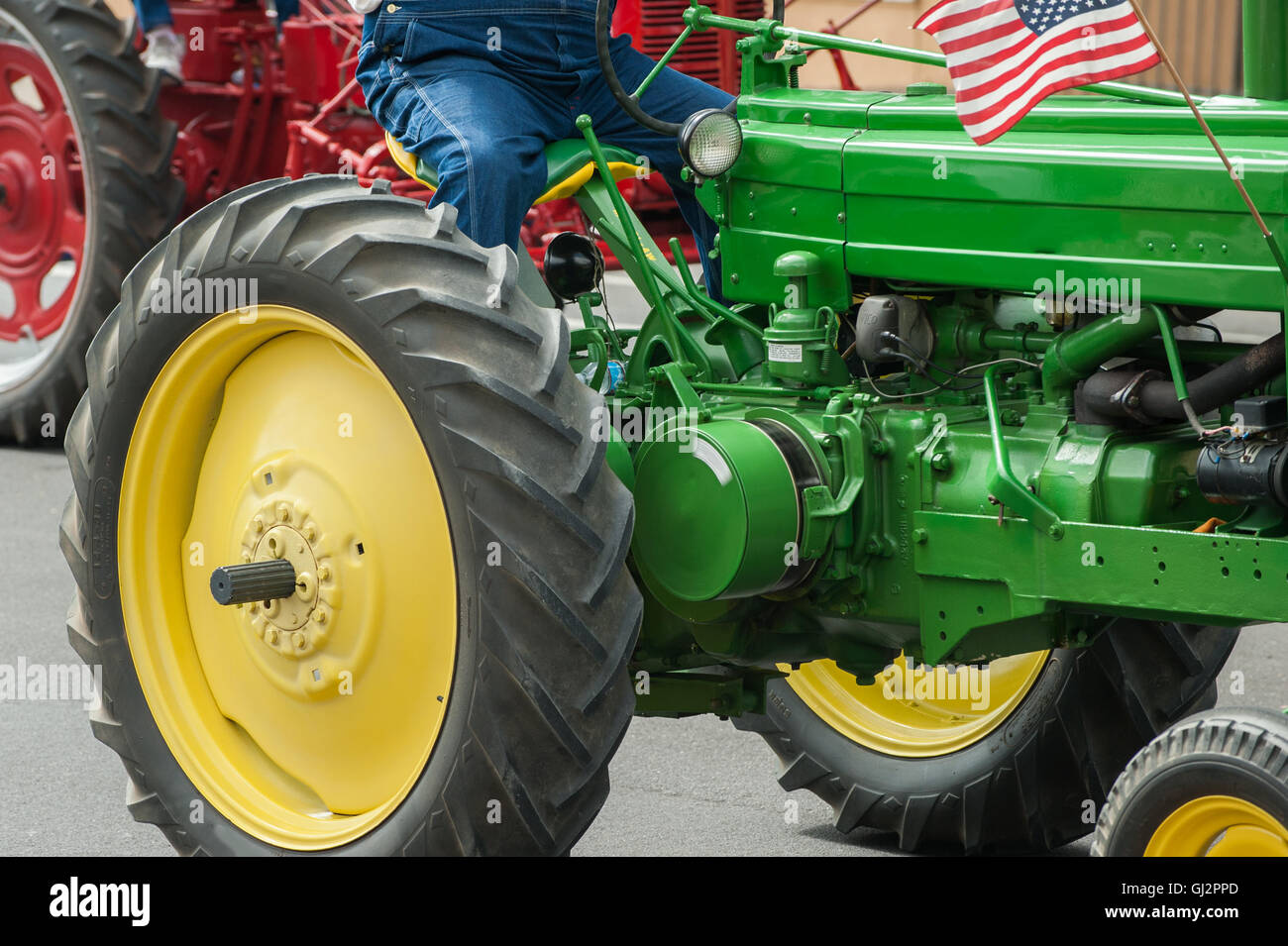 Vintage tracteur vert conduit par agriculteur Banque D'Images
