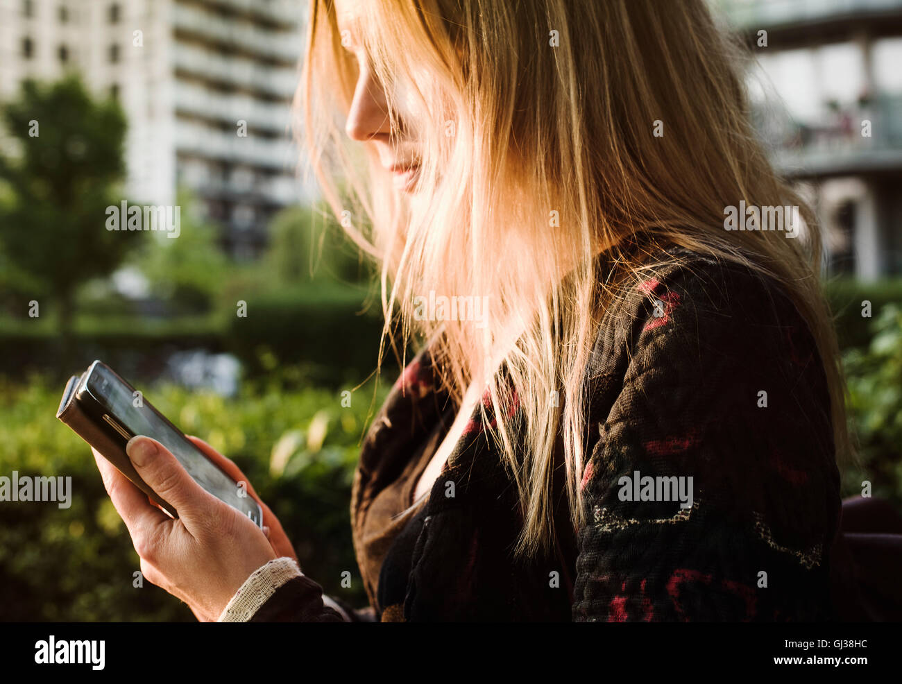 Jeune femme à l'extérieur, using smartphone Banque D'Images