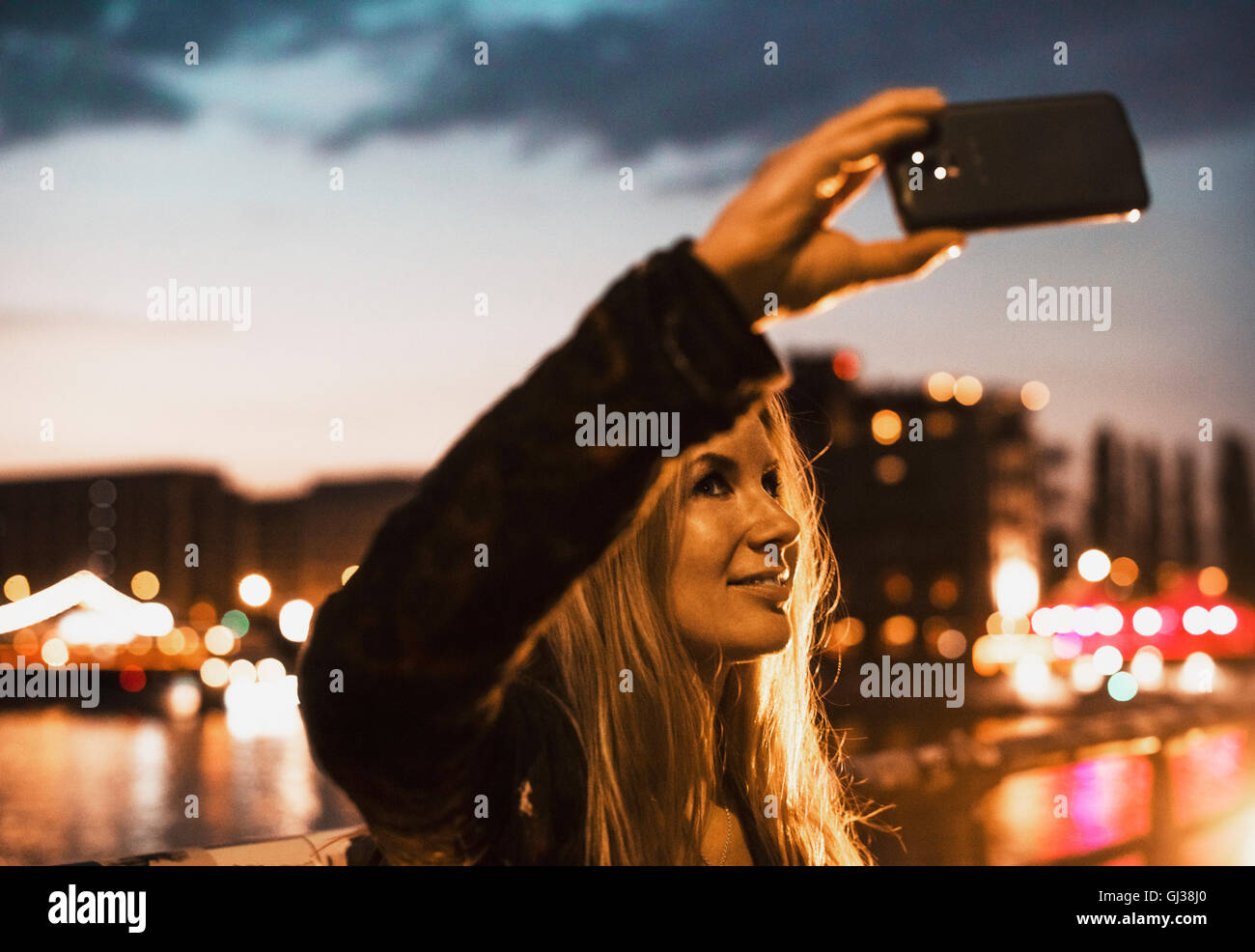 Jeune femme en bord de mer, en tenant avec smartphone selfies Banque D'Images