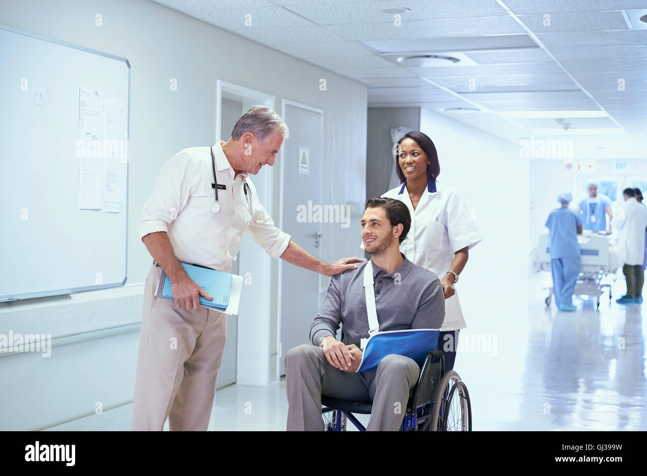 Médecin consultant avec l'homme en fauteuil roulant avec l'élingue de bras Banque D'Images