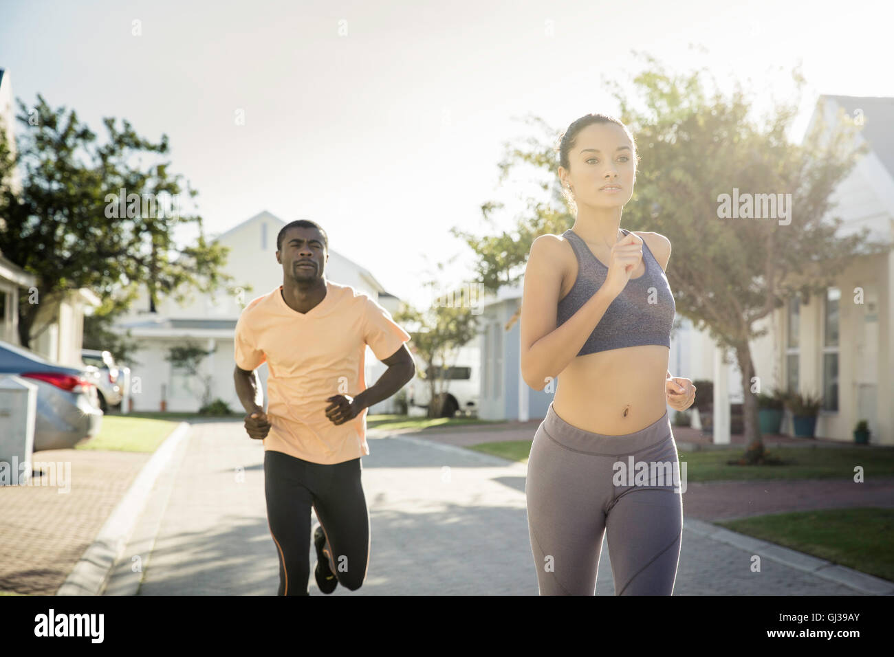 Couple jogging dans quartier résidentiel Banque D'Images