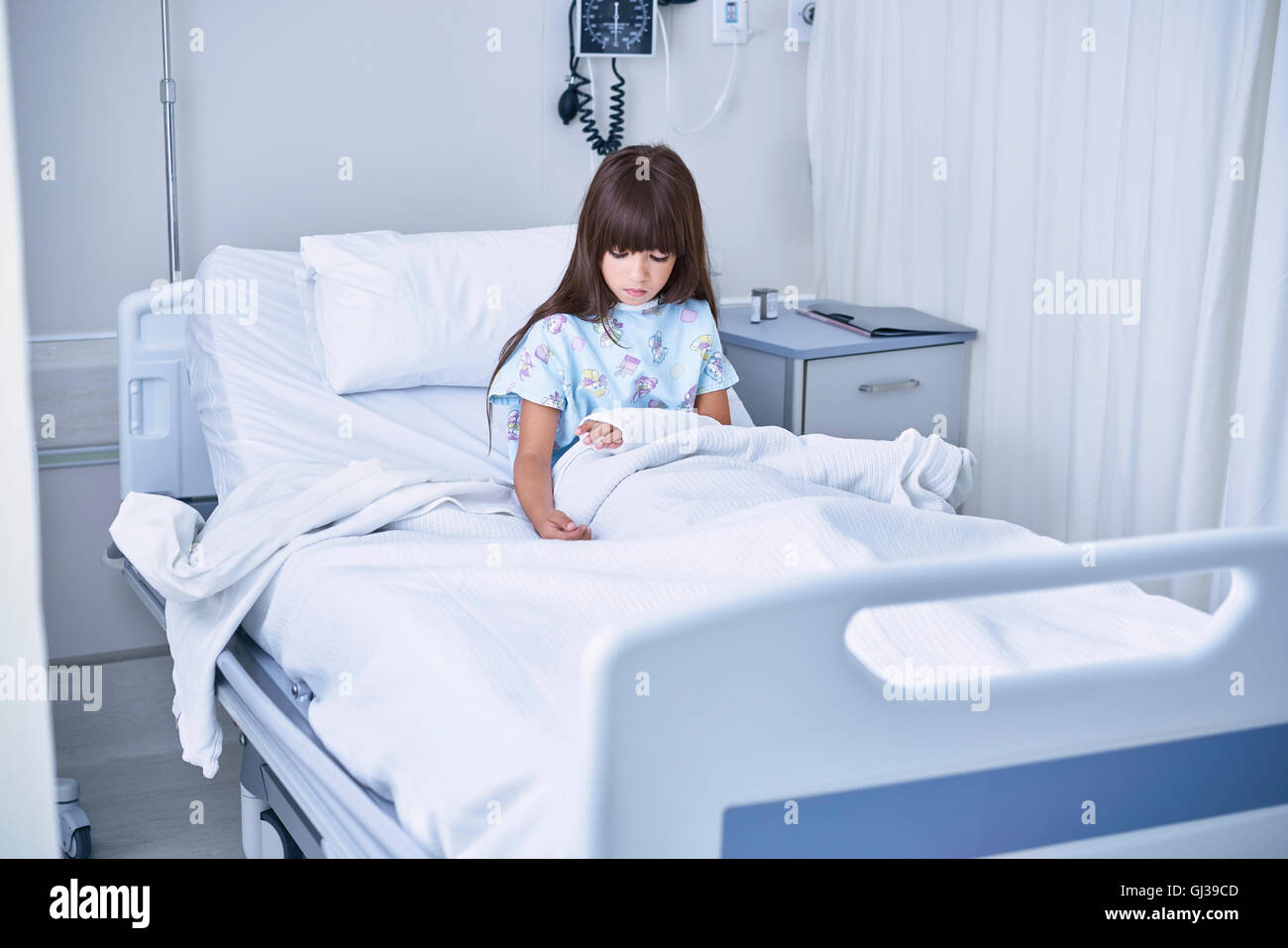 Fille au lit du patient regardant le plâtre du bras à l'hôpital de pédiatrie Banque D'Images