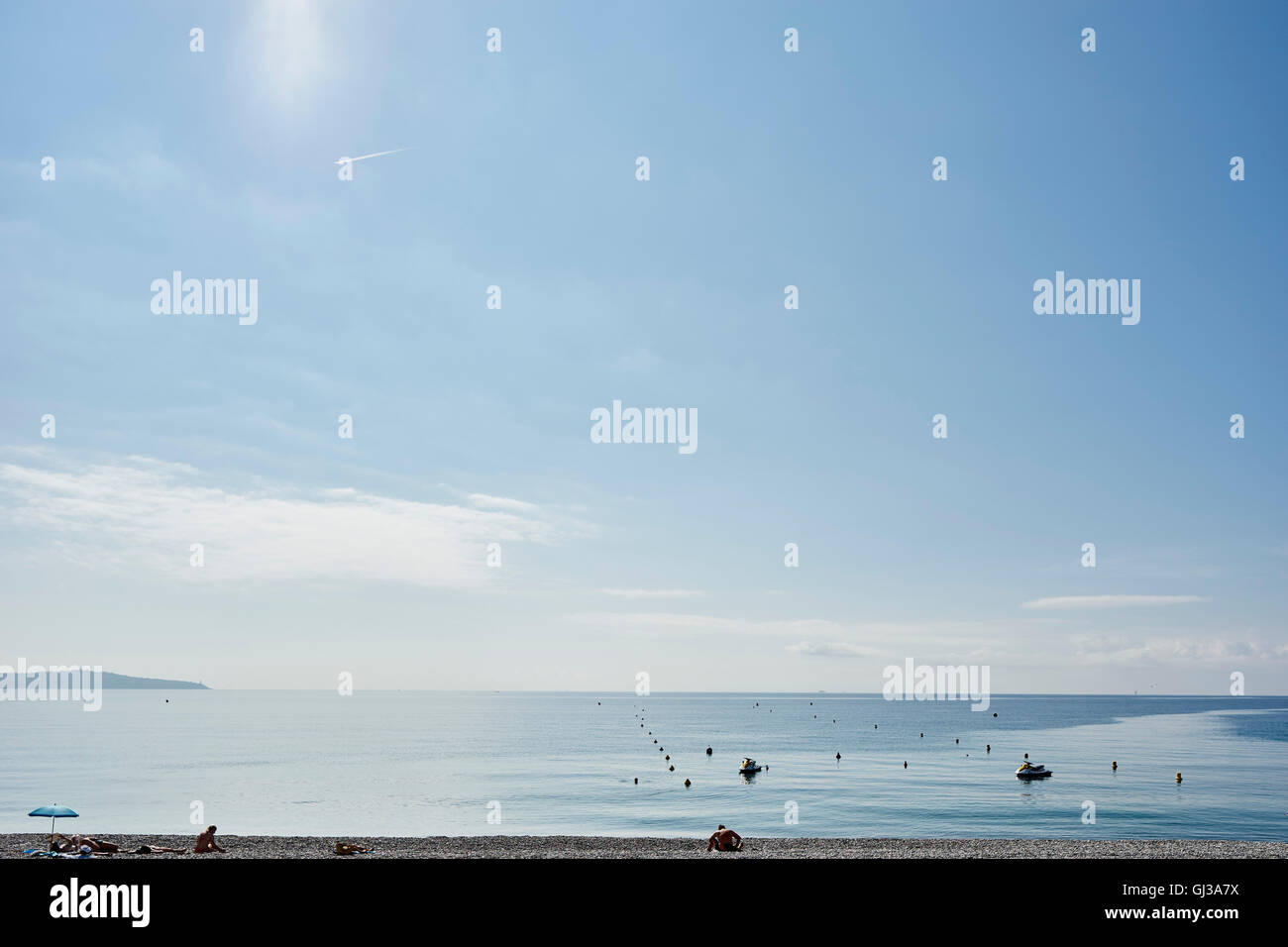 Les touristes de soleil sur plage, Nice, Côte d'Azur, France Banque D'Images