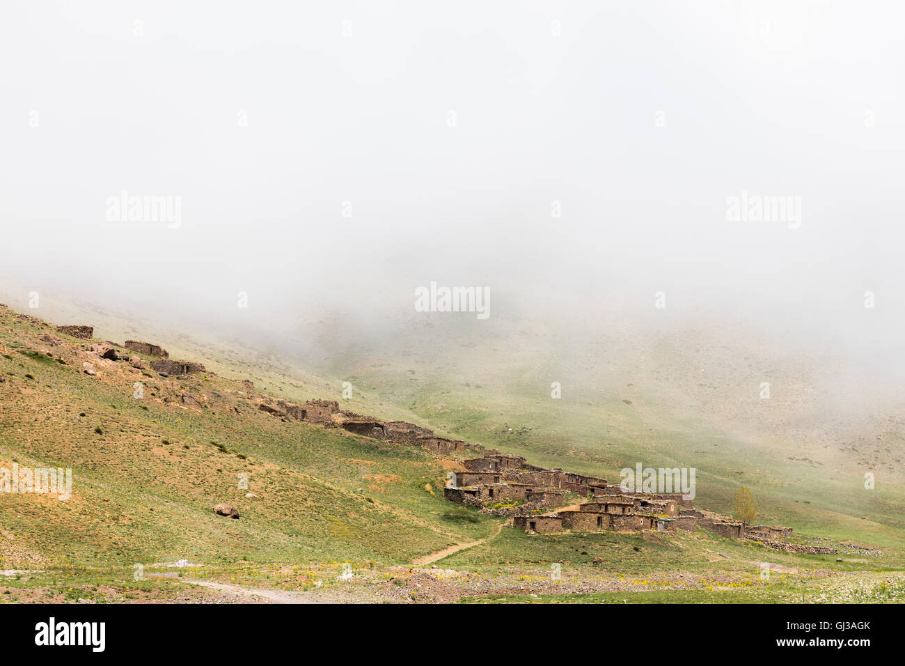 Misty vue paysage de maisons en pierre sur la colline, la station de ski de l'Oukaimeden, Marrakech, Maroc Banque D'Images