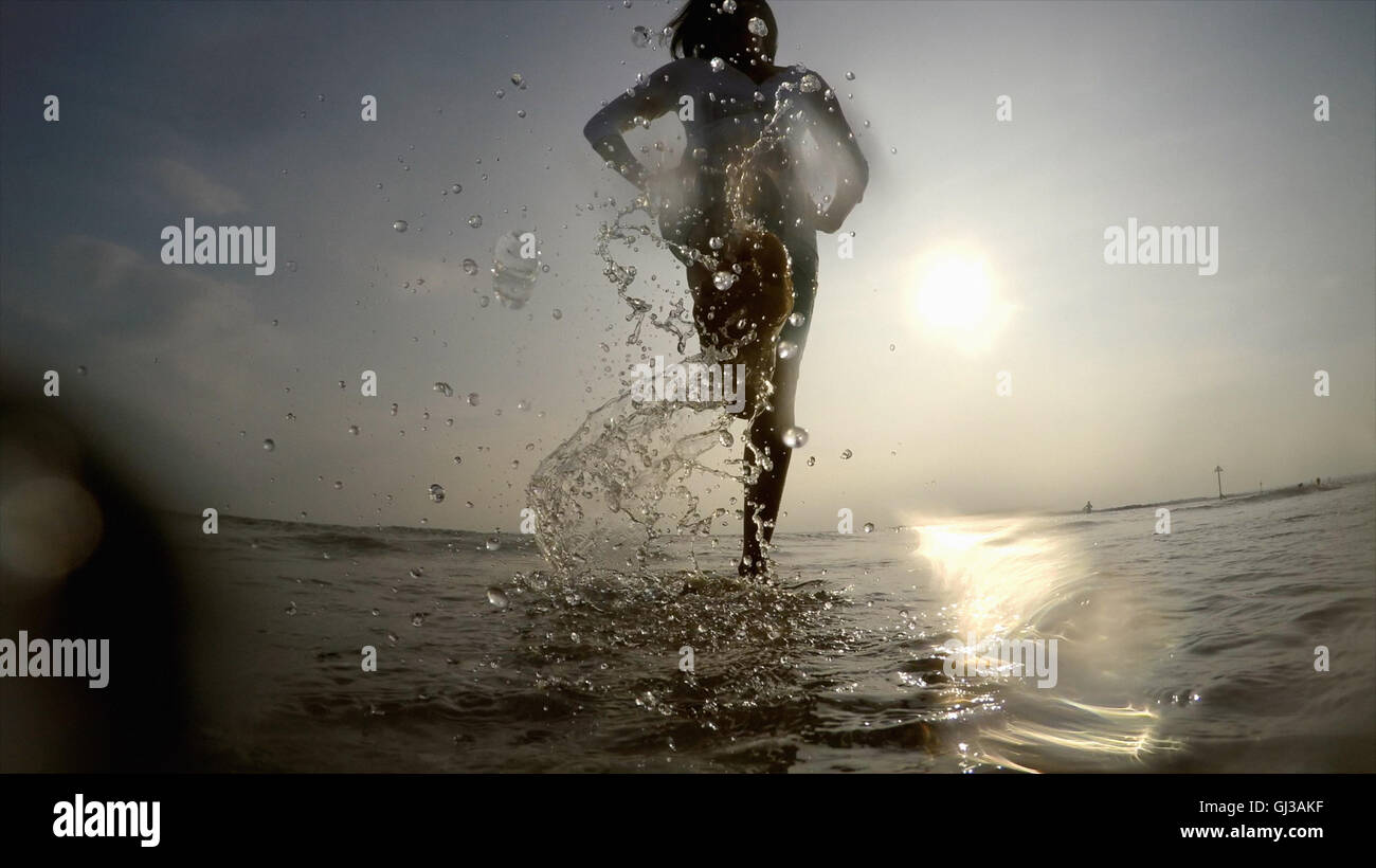 Femme dans les projections d'eau de l'océan Banque D'Images