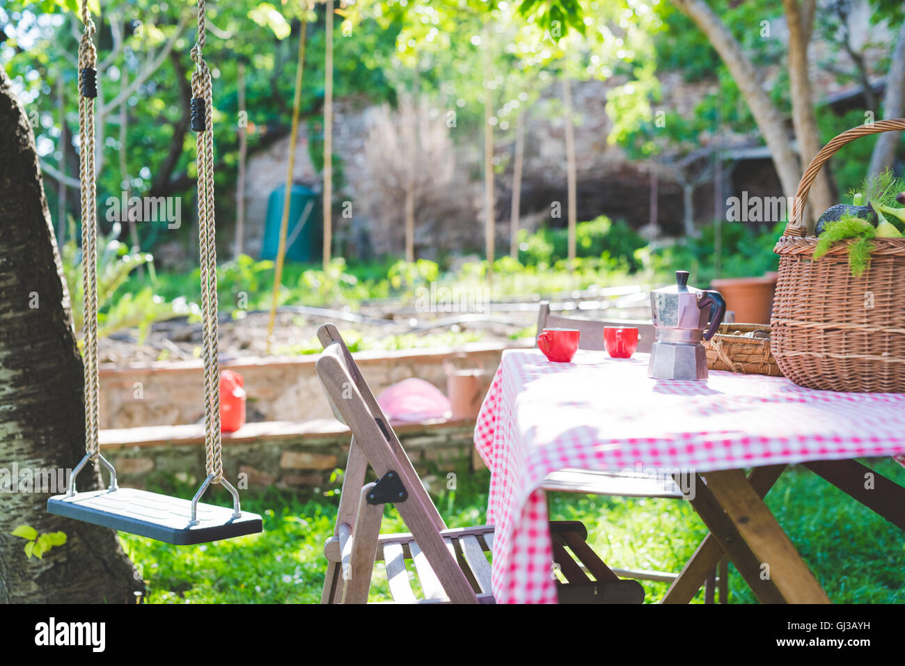 Table de jardin avec des tasses à espresso et machine à expresso Banque D'Images