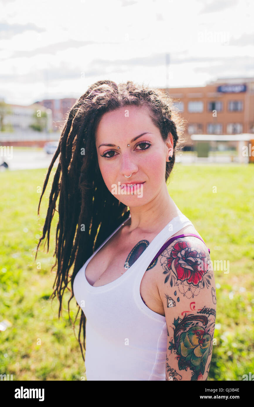 Portrait de jeune femme tatouée en parc urbain Banque D'Images