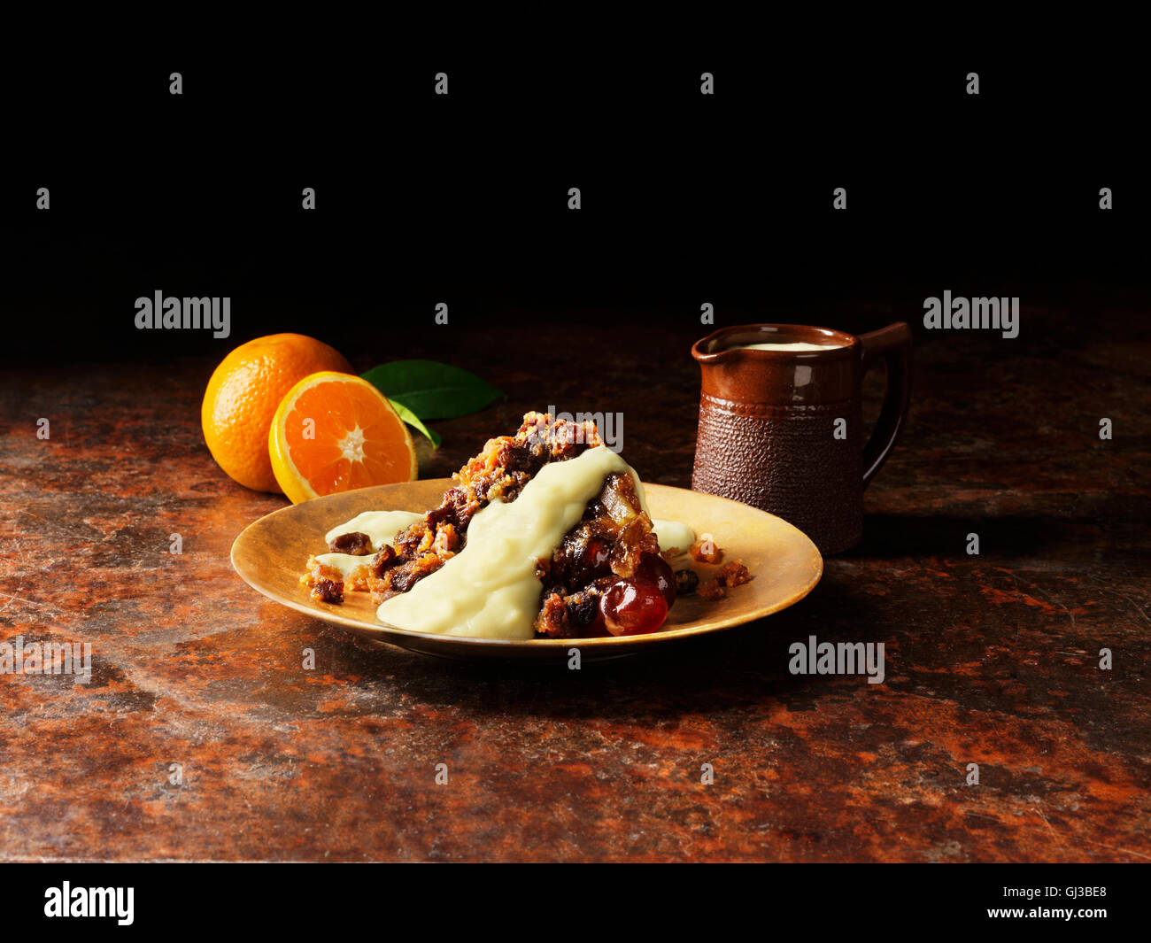 Le pudding de Noël avec la liqueur et sauce à l'orange sur la plaque d'or, les oranges, vintage pot de sauce Banque D'Images