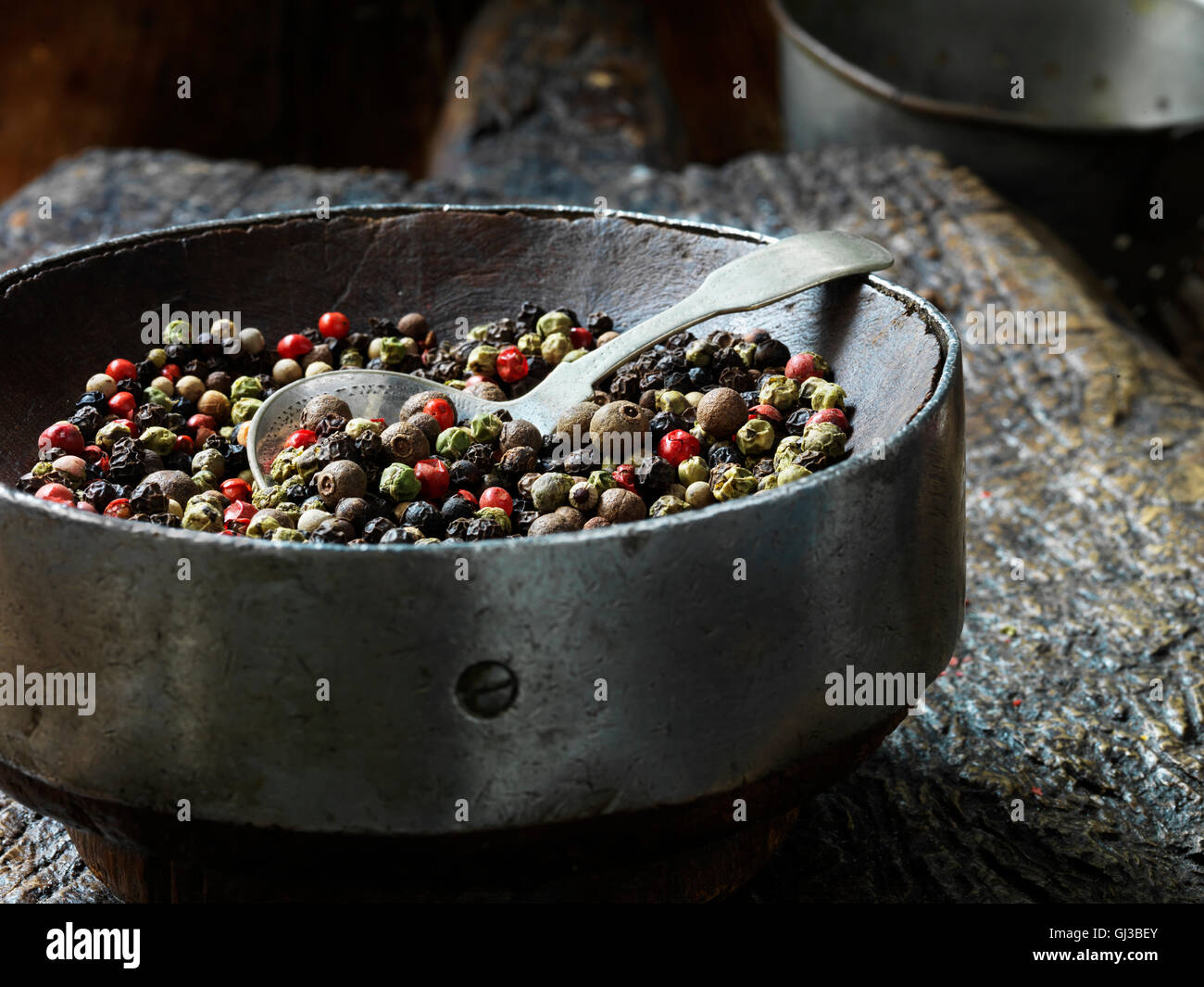 Tous les spice dans vintage bol, planche à découper en bois rustique Banque D'Images Tous les spice dans vintage bol, planche à découper en bois rustique Banque D'Images