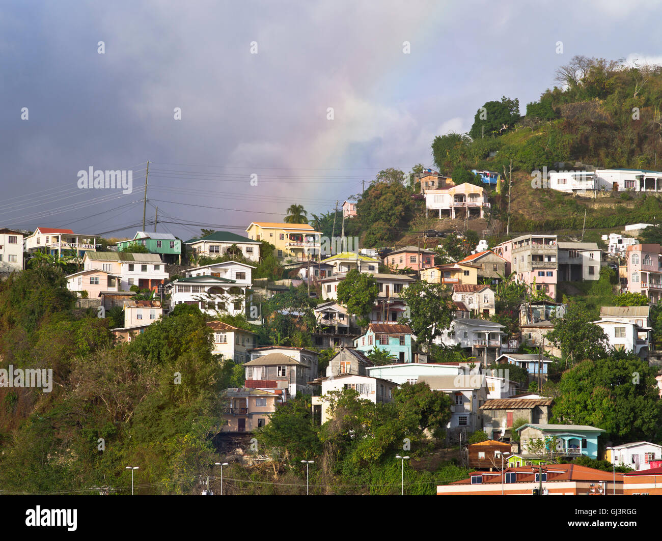 dh St George GRENADE CARAÏBES Saint Georges Caraïbes maisons on nuages orageux à flanc de colline arc-en-ciel Banque D'Images