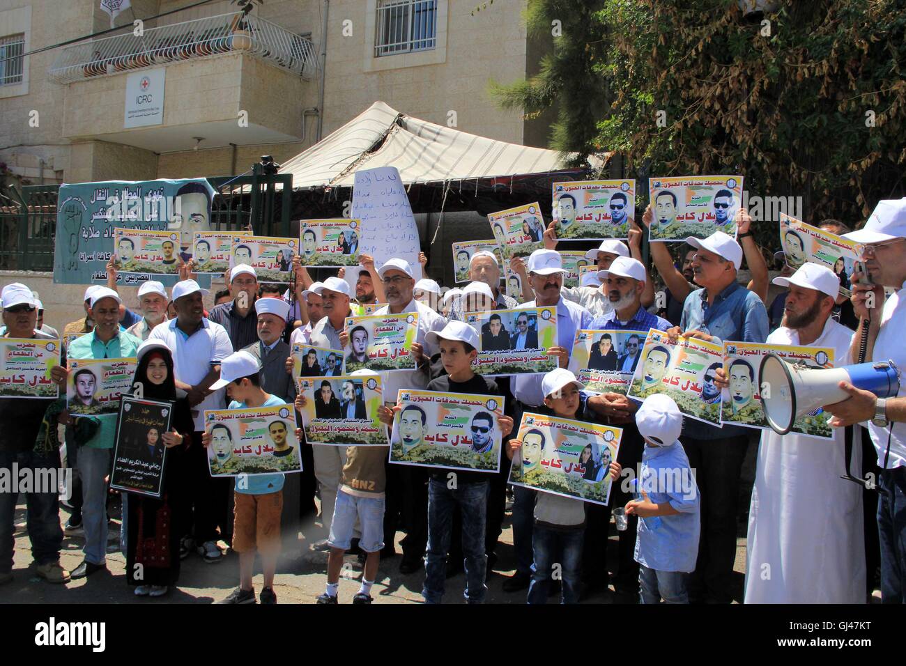 Jérusalem, Jérusalem, territoire palestinien. 12Th Aug 2016. Des manifestants palestiniens tenir affiches contre la détention administrative et à l'appui du prisonnier palestinien Bilal Kayed (portrait), qui avait jeûné pendant près de deux mois au cours de sa détention sans procès, comme ils démontrent à l'extérieur de la Croix-Rouge à Jérusalem est le 12 août 2016. Credit : ZUMA Press, Inc./Alamy Live News Banque D'Images