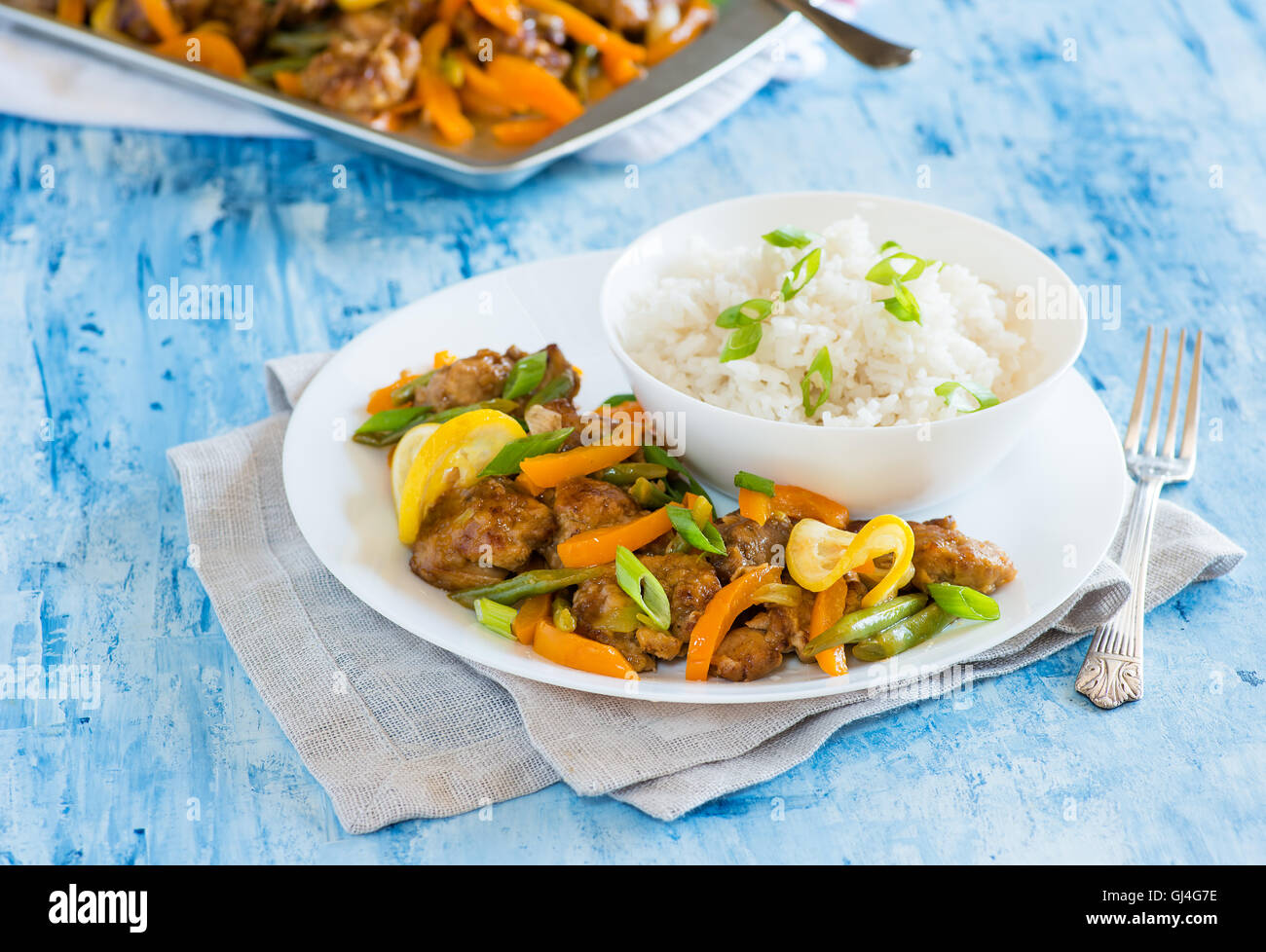 Sauté de poulet aux poivrons rouges et haricots verts au citron glaçage. Poulet style asiatique sur la plaque, portrait, gros plan Banque D'Images