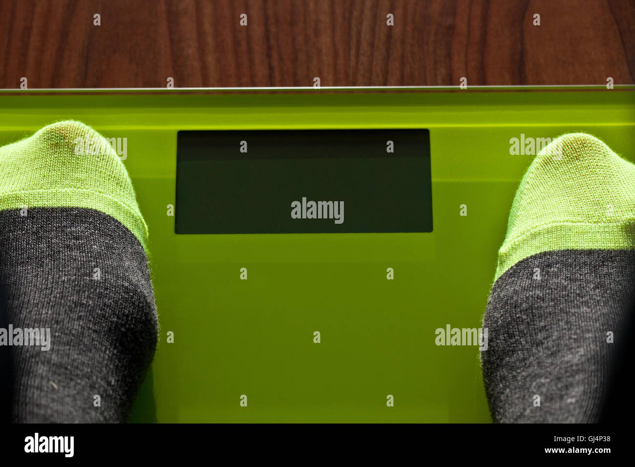 Pieds de chaussettes en couleur gris et vert sur les échelles de pondération Banque D'Images