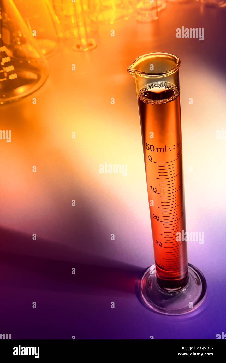 Laboratoire scientifique cylindre gradué rempli de liquide orange pour une expérience scientifique dans un laboratoire de recherche scientifique Banque D'Images