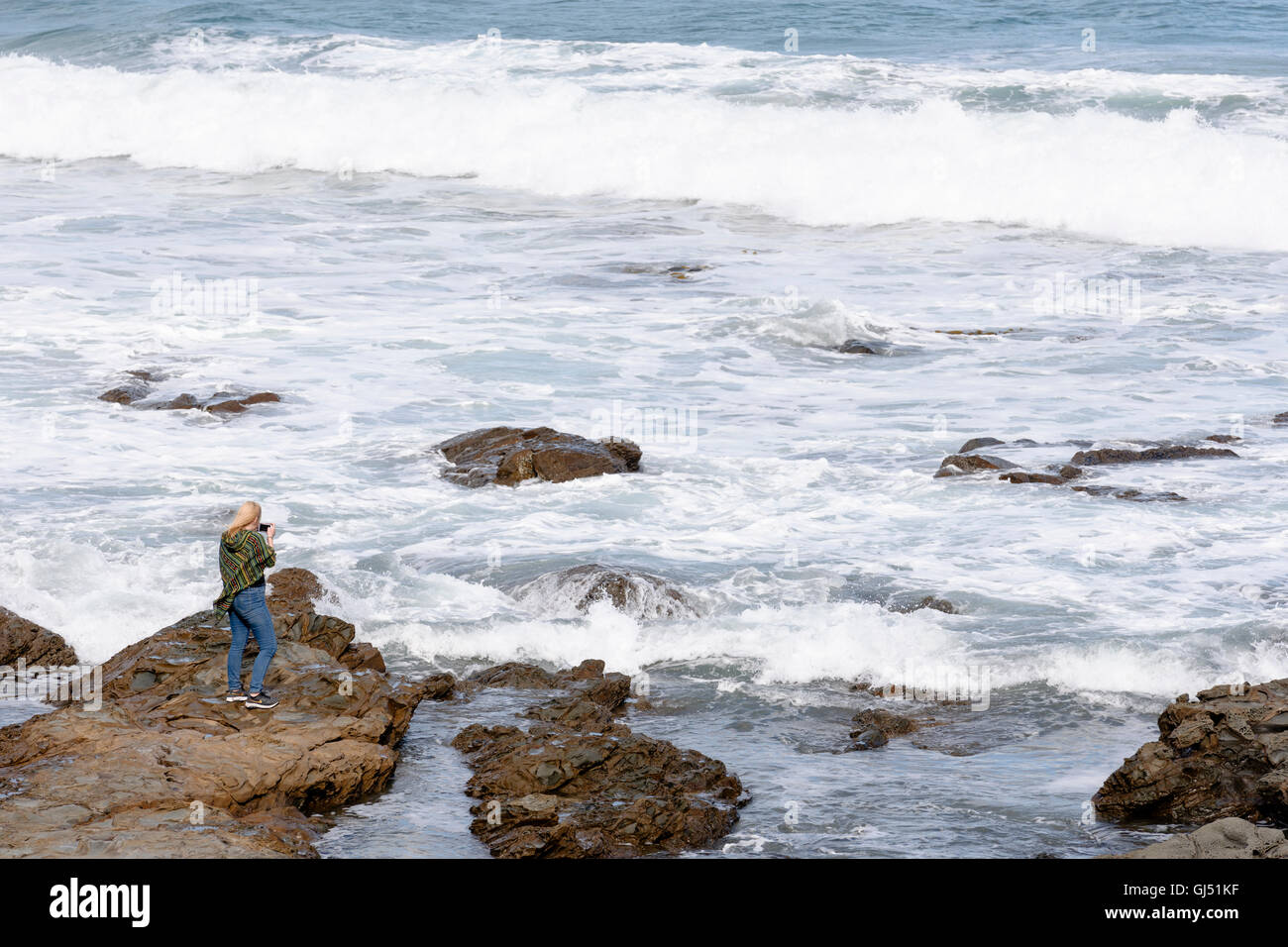 Une femme en photographiant les vagues au Jade Stadium Creek le long de la Great Ocean Road. Banque D'Images