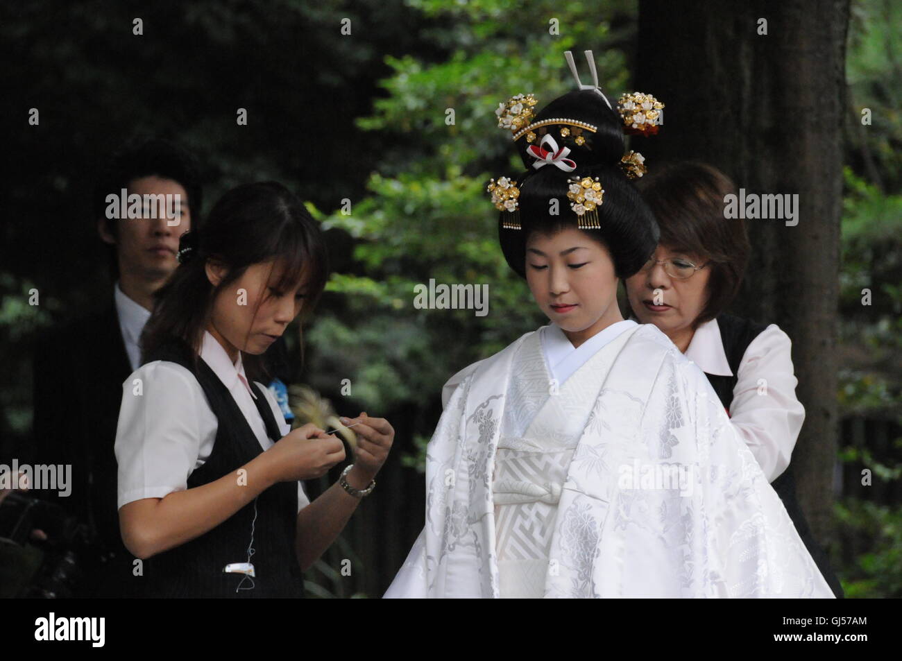 Obtenir son épouse japonaise kimono de cérémonie blanc prêt pour suite nuptiale avec l'aide de 2 autres femmes professionnelles états-majors à Tokyo Banque D'Images