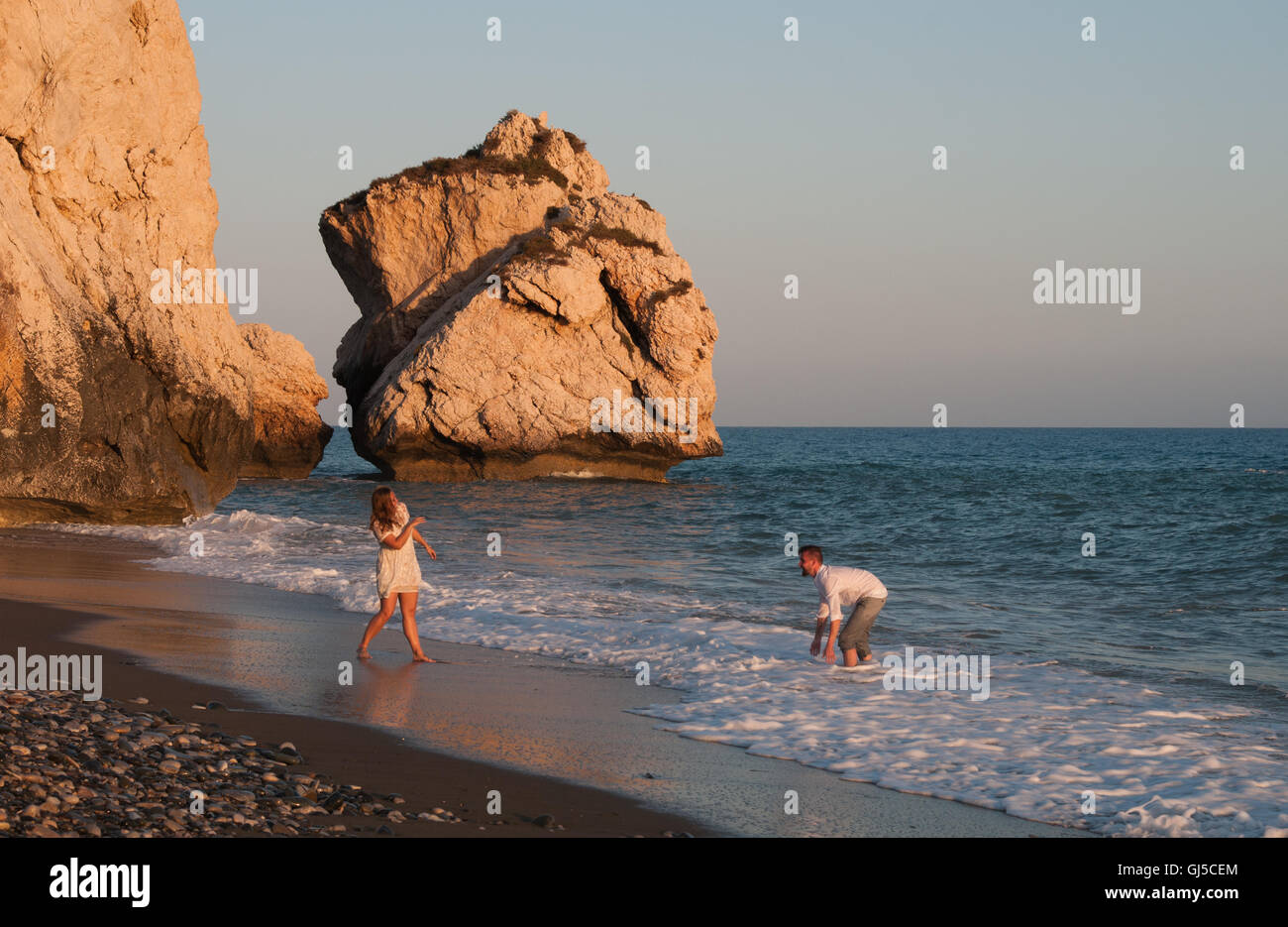 Belle et jeune couple heureux de jouer avec de l'eau à l'endroit de naissance d'Aphrodite Beach à Paphos, Chypre Banque D'Images