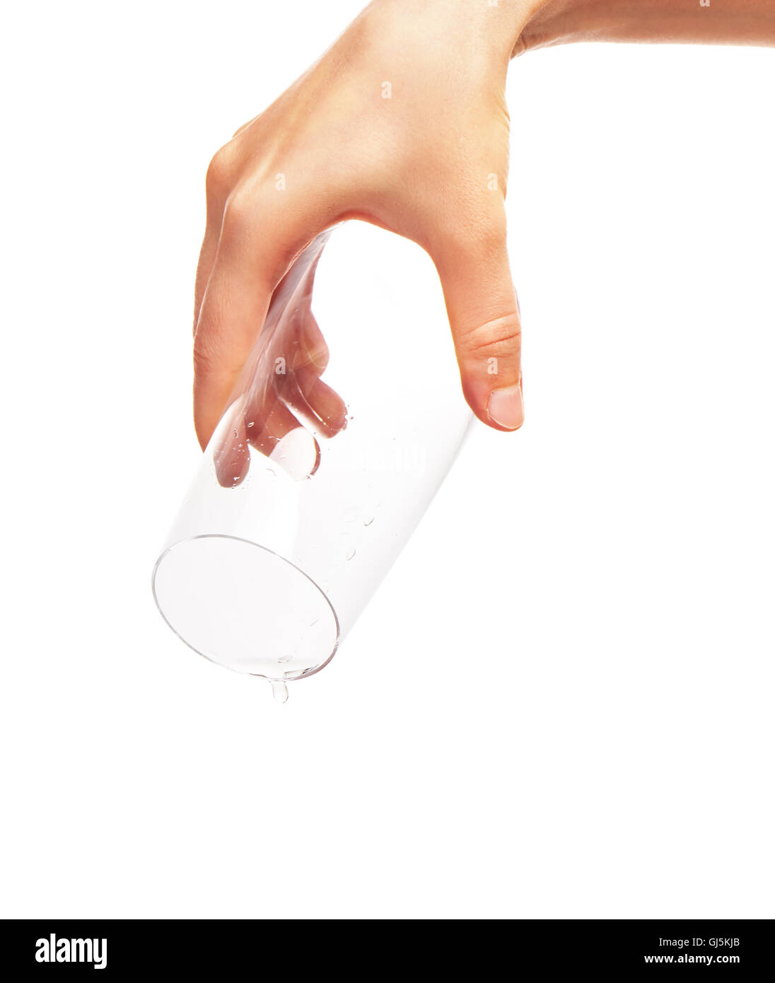 Goutte d'eau tombant de verre vide dans la main de femme isolé sur fond blanc. Chemin de détourage pour bordure en verre Banque D'Images